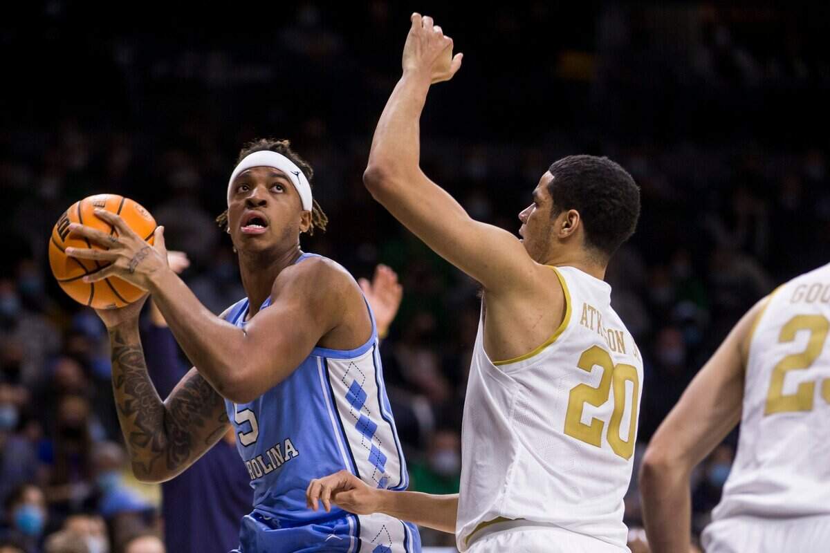 North Carolina’s Armando Bacot (5) looks for a shot with pressure from Notre Dame’s Paul Atkinson Jr. (20) during the first half of an NCAA college basketball game Wednesday, Jan. 5, 2022, in South Bend, Ind. (AP Photo/Robert Franklin)