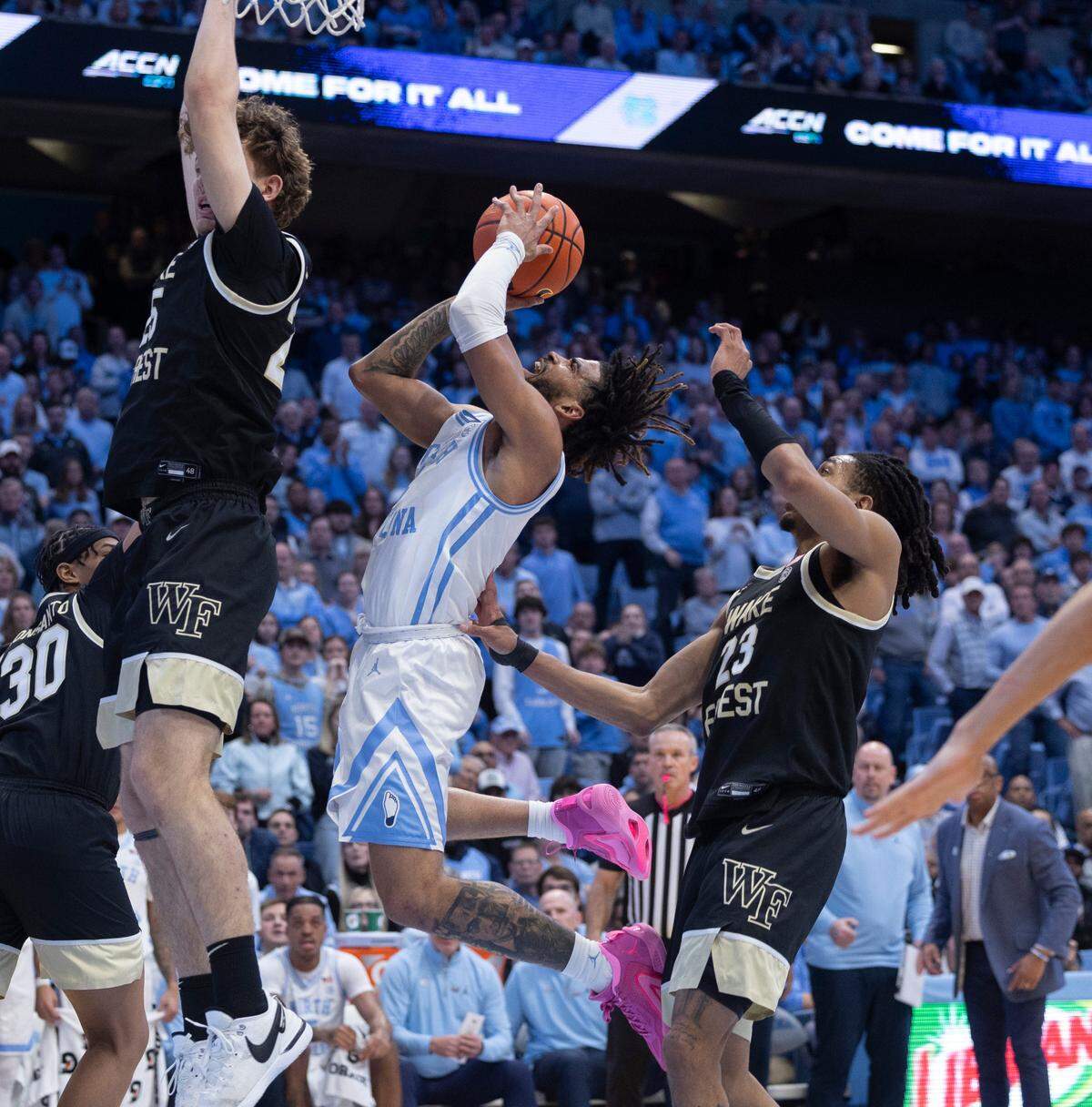 North Carolina’s R.J. Davis (4) breaks through the Wake Forest defense of Damari Monsanto (30), Zach Keller (25) and Hunter Sallis (23) in the second half on Monday, January 22, 2024 at the Smith Center in Chapel Hill, N.C.