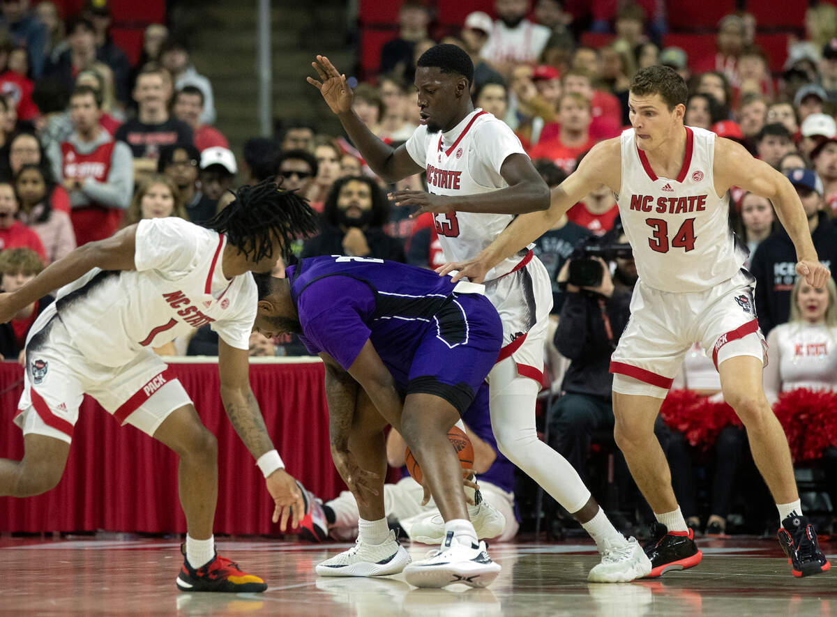 Abilene Christian’s Airion Simmons is swarmed by N.C. State’s Jayden Taylor, Mohamed Diarra and Ben Middlebrooks during the first half of the Wolfpack’s 84-64 win on Friday, Nov. 10, 2023, at PNC Arena in Raleigh, N.C.