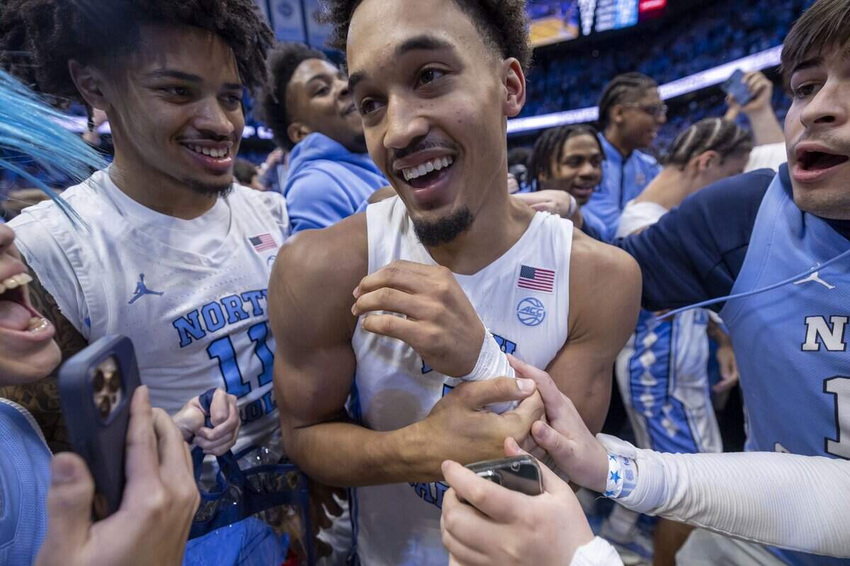 North Carolina guard Seth Trimble (7) reacts as fans storm the court, after sinking a three-point shot with .4 seconds to play, to give the Tar Heels a 71-68 victory over Duke on Saturday, February 7, 2026 at the Smith Center in Chapel Hill, N.C.