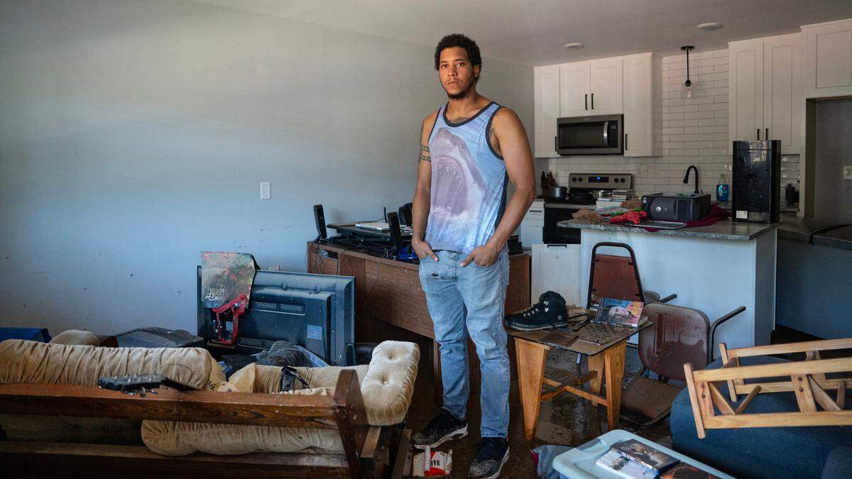 Aidan Akkari stands in his apartment the morning after severe flooding on Sunday, July 6, 2025 during Tropical Storm Chantal. Feet of rushing water entered his apartment, forcing him to evacuate via car. He returned to find his home and belongings covered with mud.
