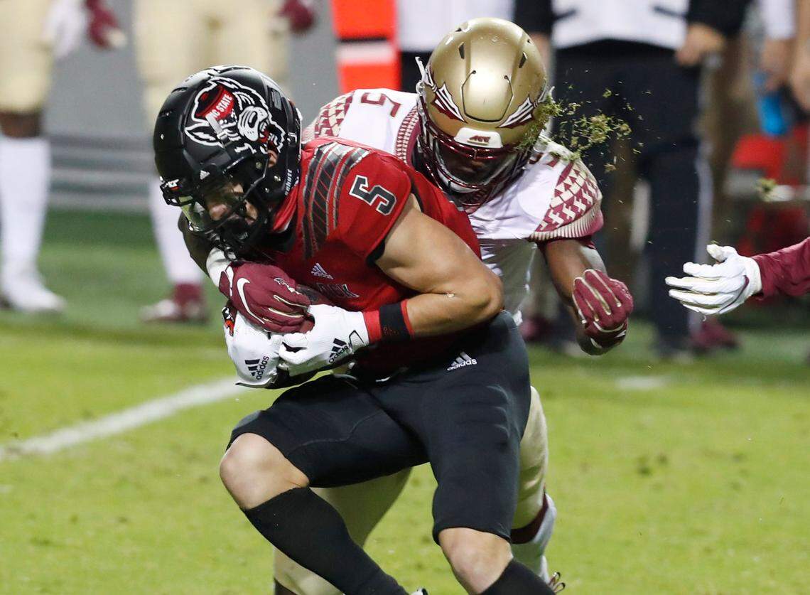 N.C. State wide receiver Thayer Thomas (5) gains yards after making the reception as Florida State defensive back Hamsah Nasirildeen (5) tries to tackle him during the first half of N.C. State’s game against Florida State at Carter-Finley Stadium in Raleigh, N.C., Saturday, Nov. 14, 2020.