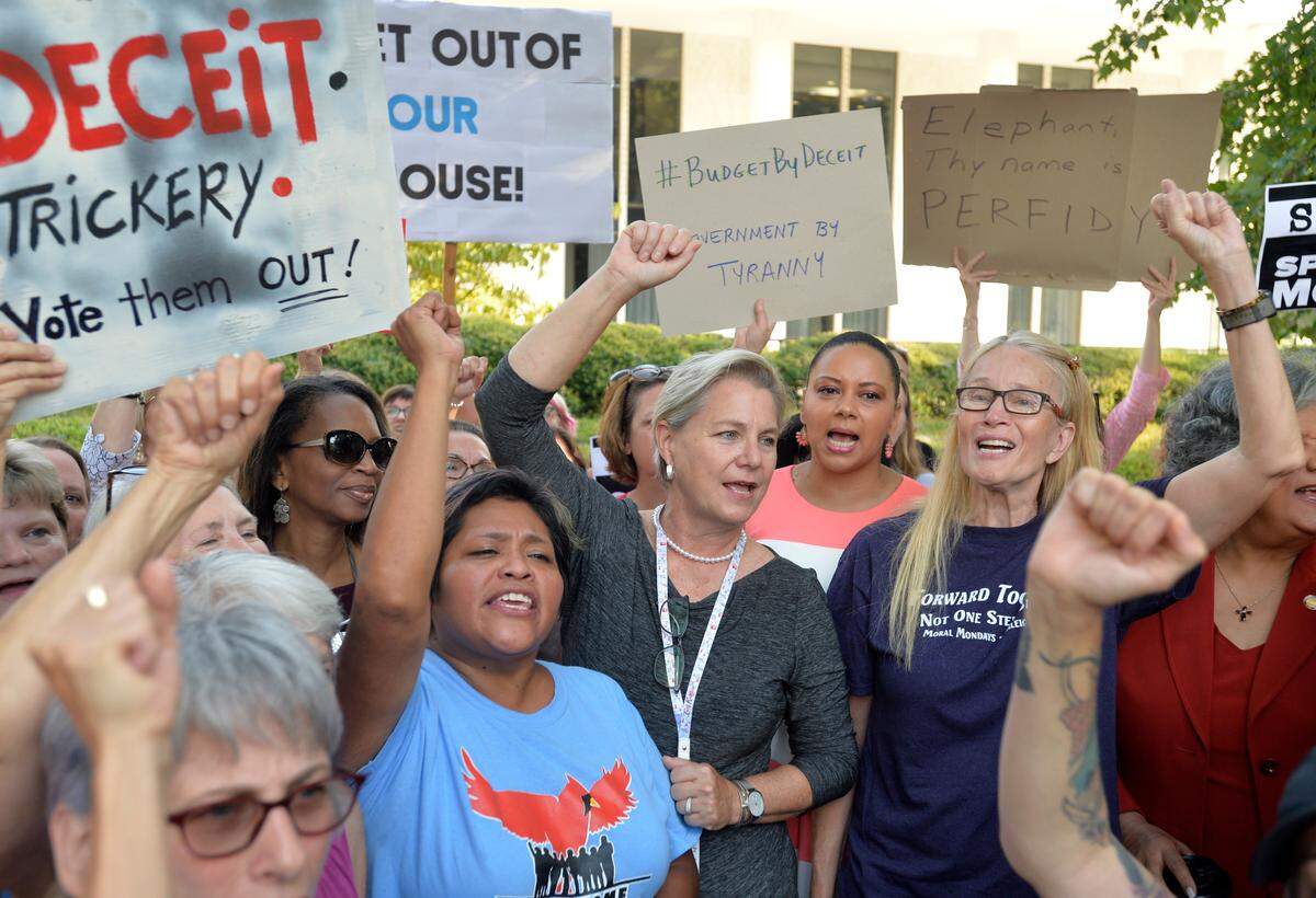 Supporters surround Rep. Deb Butler and chant “Refuse to Yield” at a rally protesting the surprise vote by the House Wednesday, Sept. 11, 2019 overriding the Governor’s veto of the budget. Butler, who spoke out loudly in opposition during the session and refused to yield the floor, attended a rally outside of the Legislature in Raleigh, N.C. Thursday morning Sept. 12, 2019.