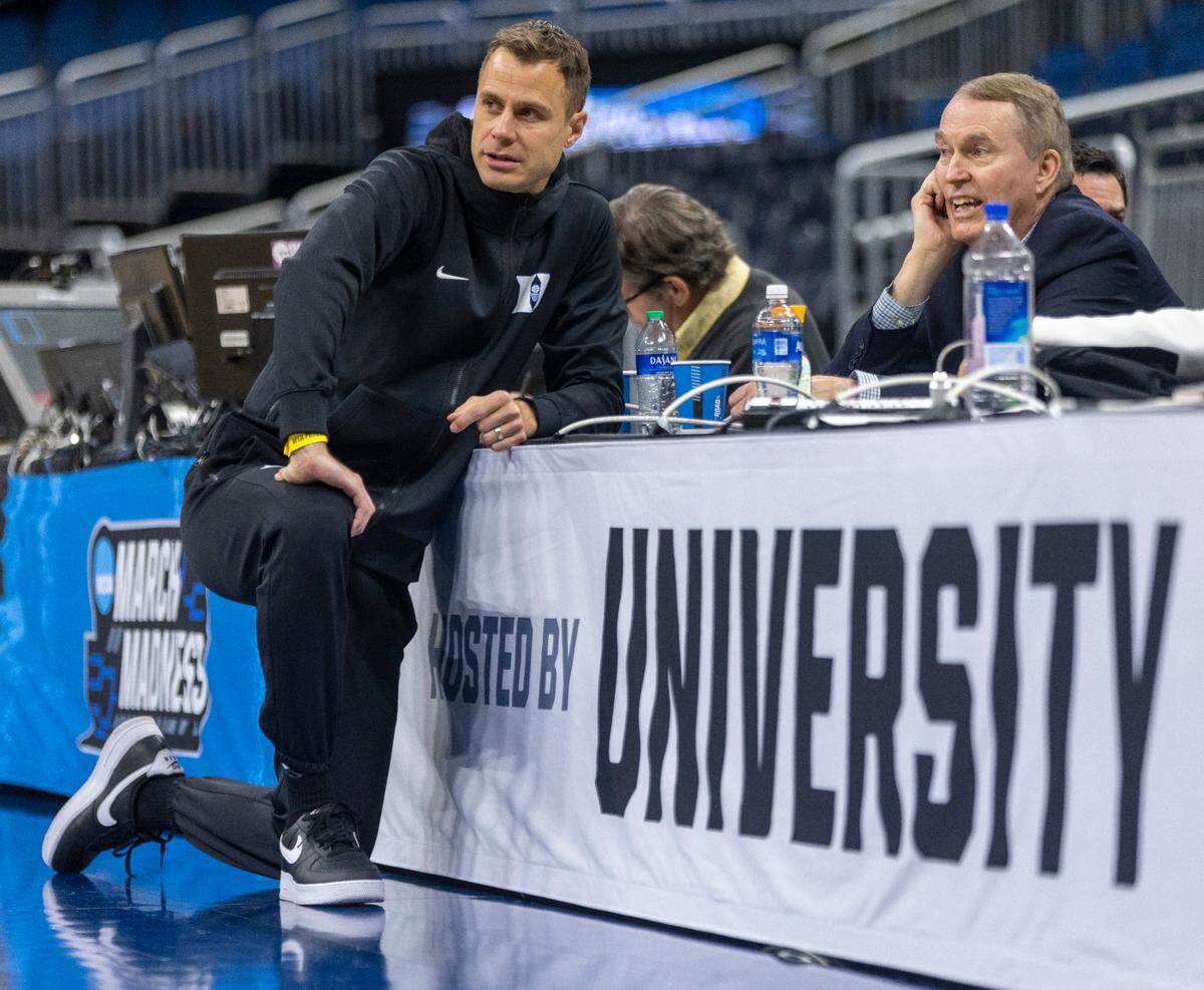 Duke head coach Jon Scheyer talks with color commentator Dan Bonner as they watch the Blue Devils’ practice on Wednesday, March 15, 2023 at the Amway Center in Orlando, Fla.