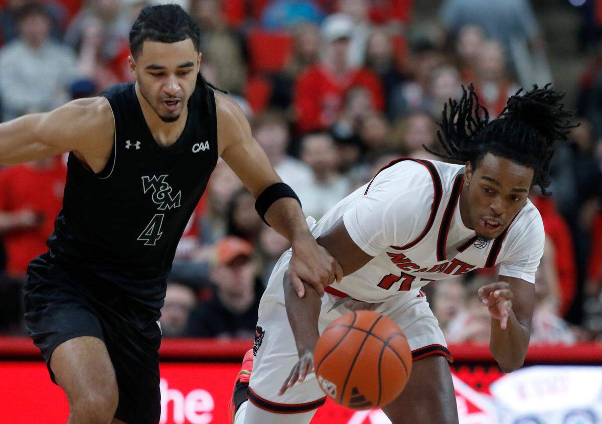 William & Mary’s Matteus Case and N.C. State’s Dennis Parker Jr. chase after a loose ball during the first half of the Wolfpack’s game at Lenovo Center on Friday, Nov. 22, 2024, in Raleigh, N.C.