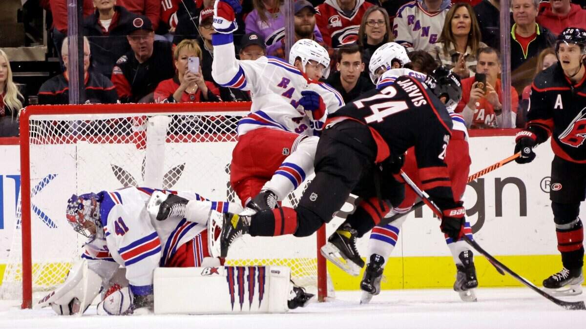 New York Rangers defenseman Niko Mikkola, center, collides with Carolina Hurricanes center Seth Jarvis (24) while goaltender Jaroslav Halak (41) covers the puck during the first period of an NHL hockey game, Saturday, Feb. 11, 2023, in Raleigh, N.C. (AP Photo/Chris Seward)