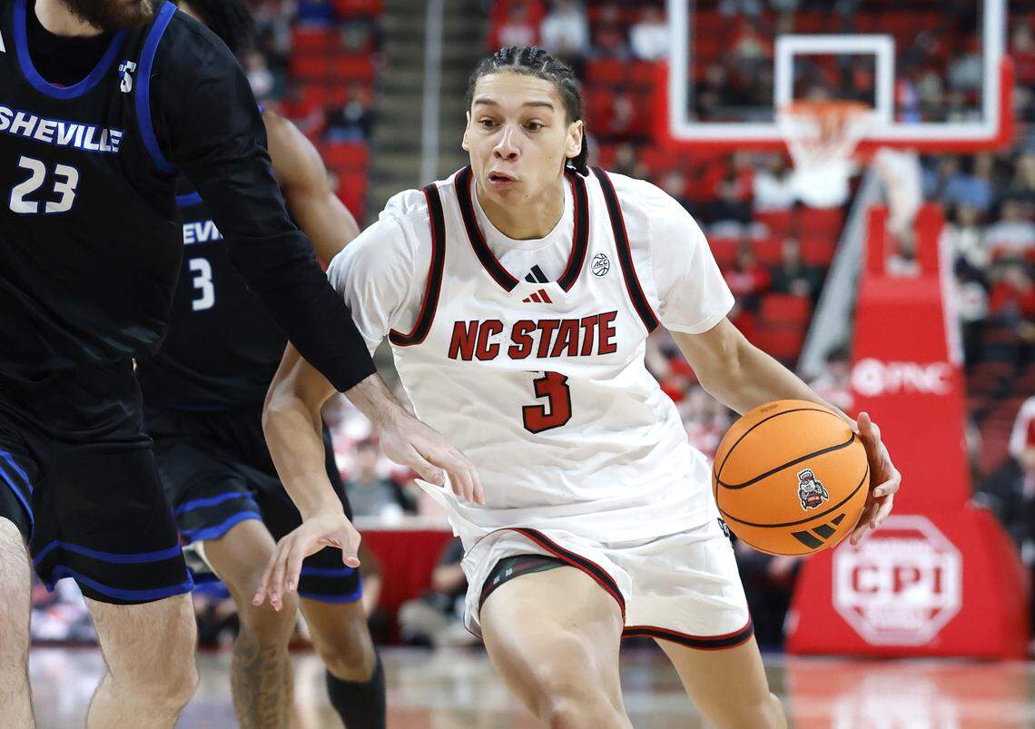 N.C. State's Matt Able (3) drives around UNC Asheville's David Hermes (23) during the second half of N.C. State’s 75-63 victory over UNC Asheville at the Lenovo Center in Raleigh, N.C., Saturday, Dec. 6, 2025.