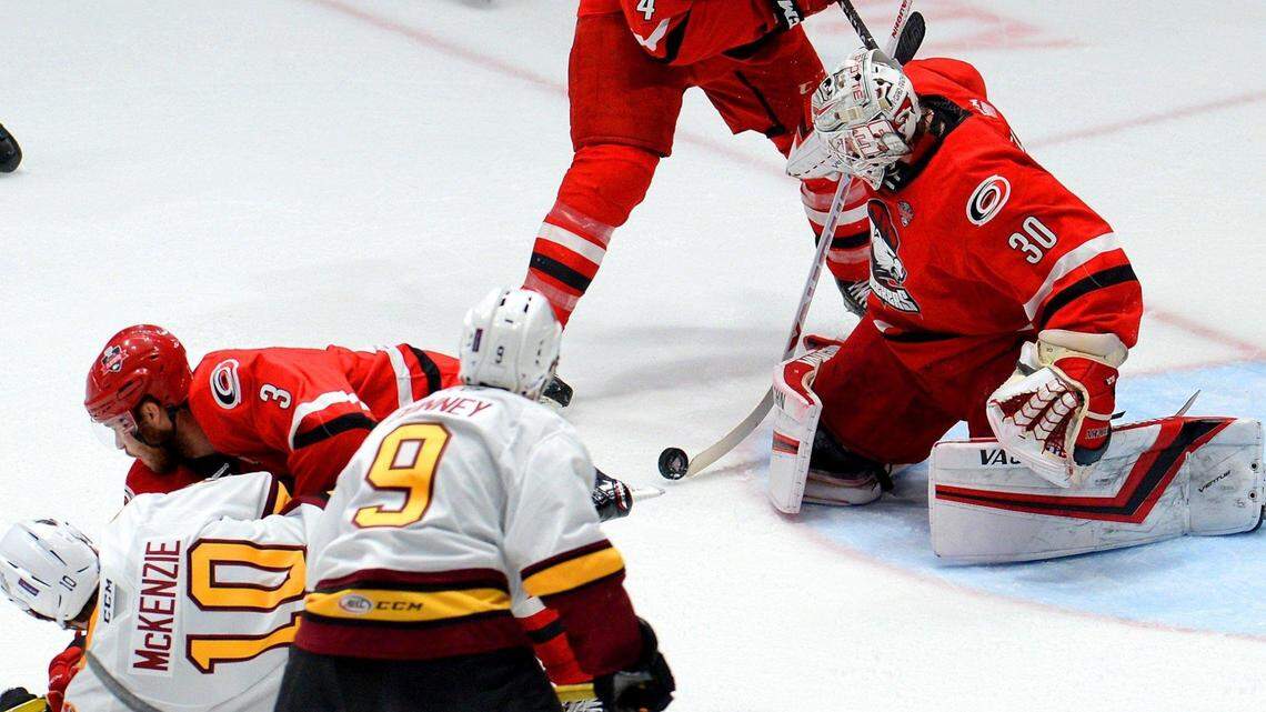 Charlotte Checkers goalie Alex Nedeljkovic, right, stops a shot on goal during Game 1 of the AHL Calder Cup Finals against the Chicago Wolves at Bojangles’ Coliseum on Saturday.