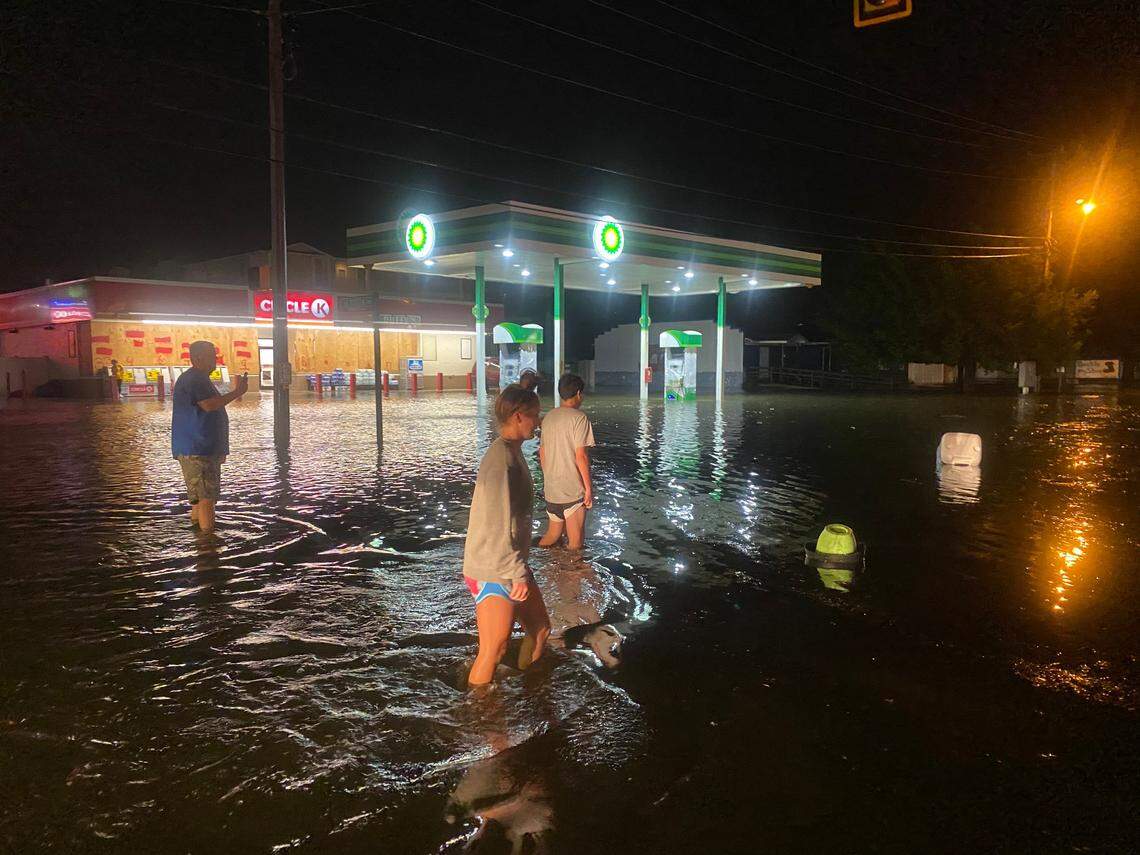 People walk along a flooded Sea Mountain Highway in the Cherry Grove portion of North Myrtle Beach on Monday night. Hurricane Isaias hit the Myrtle Beach area Monday night.