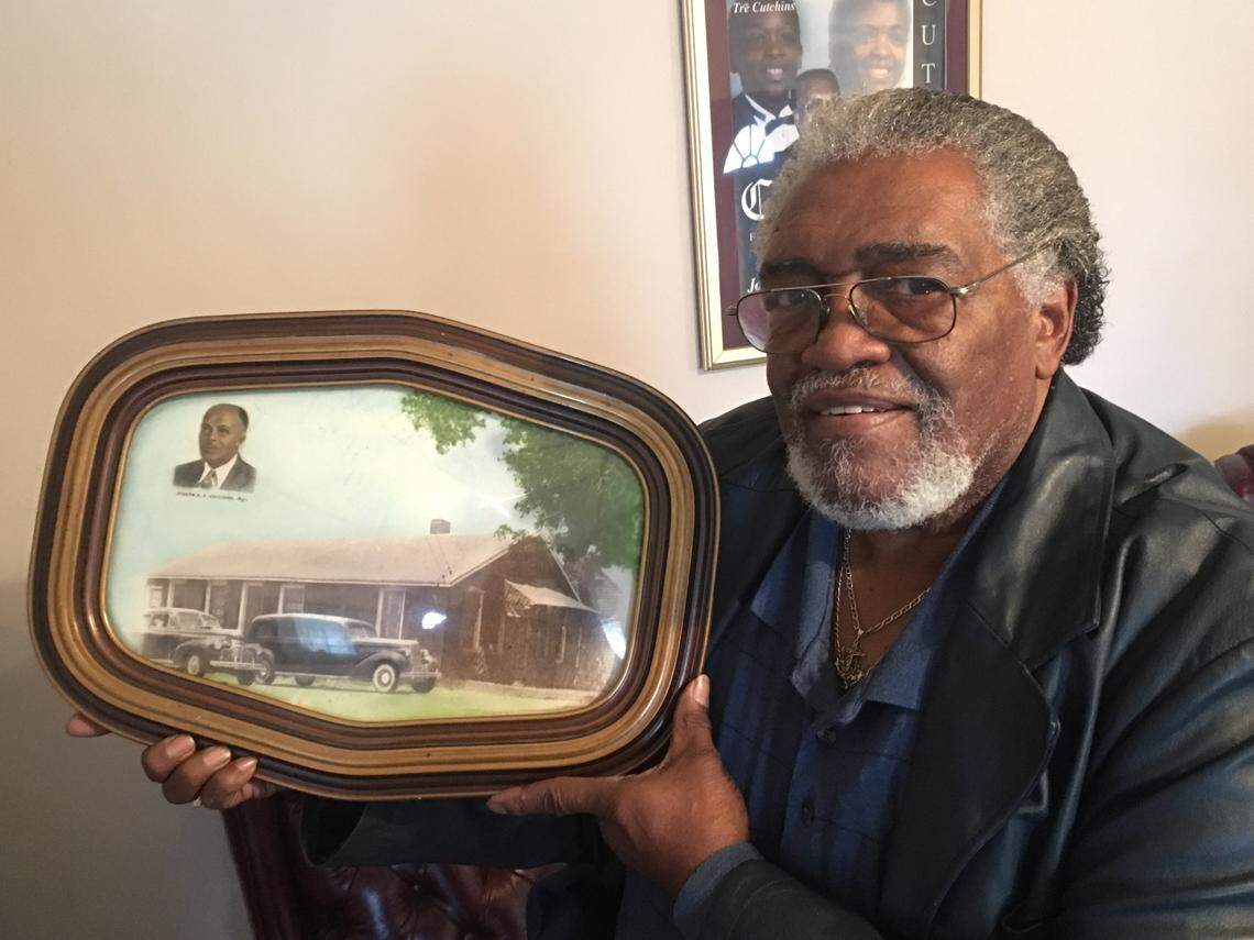 Joe Cutchins, whose father heard the crash that killed boxer Jack Johnson in Franklinton, can still point out the spot. He holds a picture of the Packard hearse that carried the boxer.