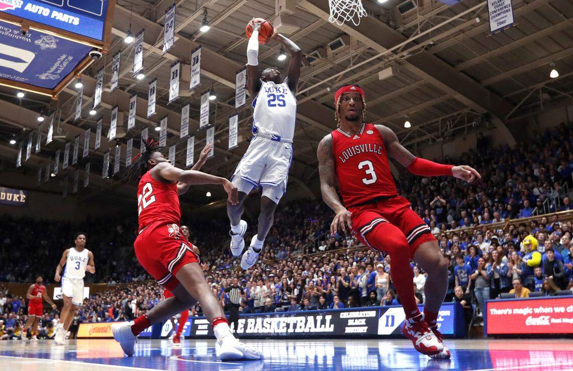 Duke’s Mark Mitchell (25) heads to slam in two past Louisville’s Kamari Lands (22) and El Ellis (3) during Duke’s 79-62 victory over Louisville at Cameron Indoor Stadium in Durham, N.C., Monday, Feb. 20, 2023.