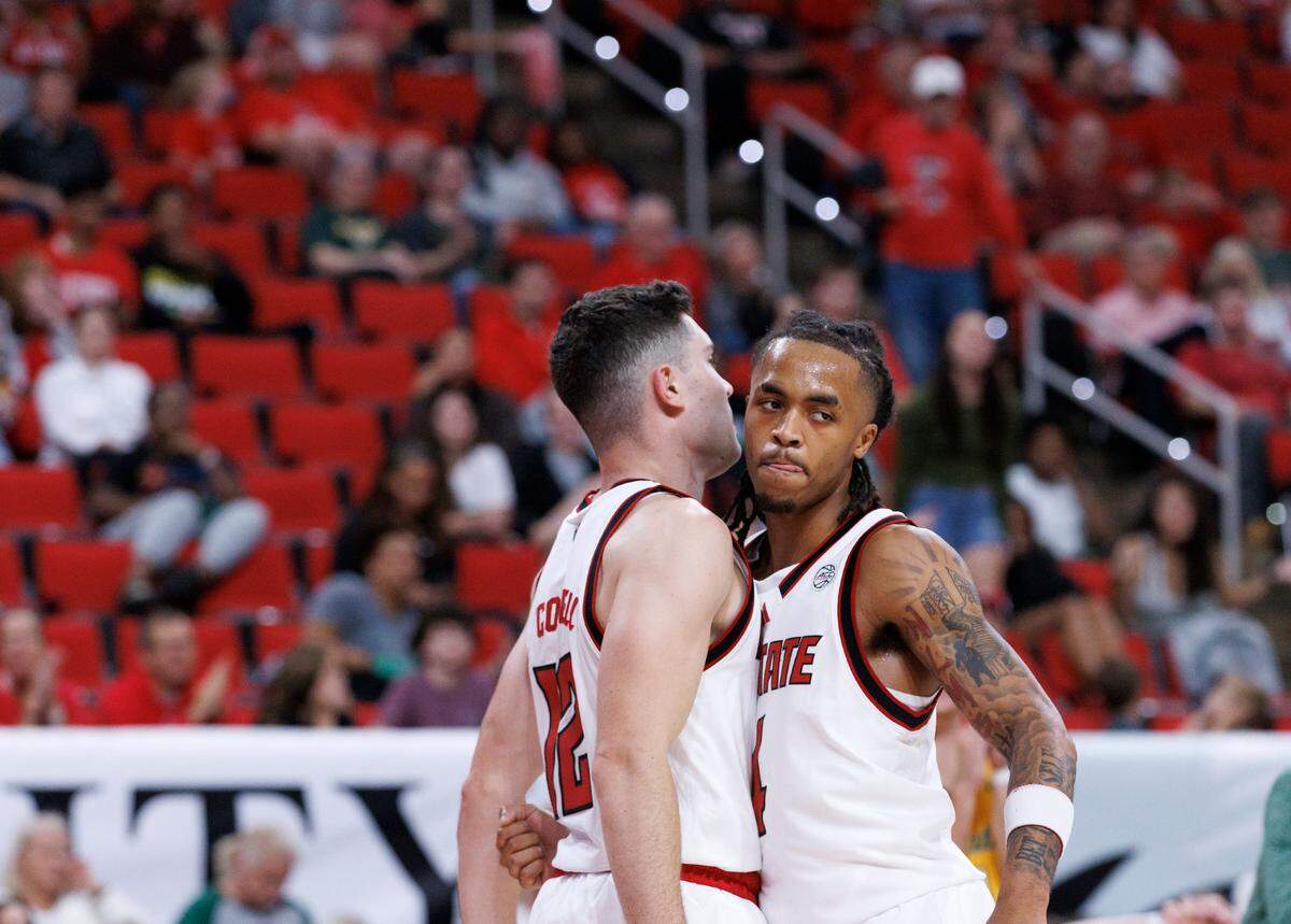 N.C. State’s Michael O’Connell is congratulated by teammate Breon Pass after drawing a blocking foul during the first half of the Wolfpack’s 79-75 exhibition win over Lees-McRae on Wednesday, Oct. 30, 2024, at the Lenovo Center.