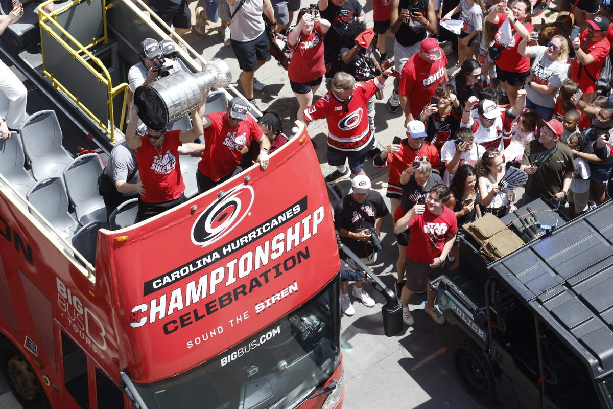 Buses carrying Carolina Hurricanes players and families along the parade route celebrating their Stanley Cup Championship.