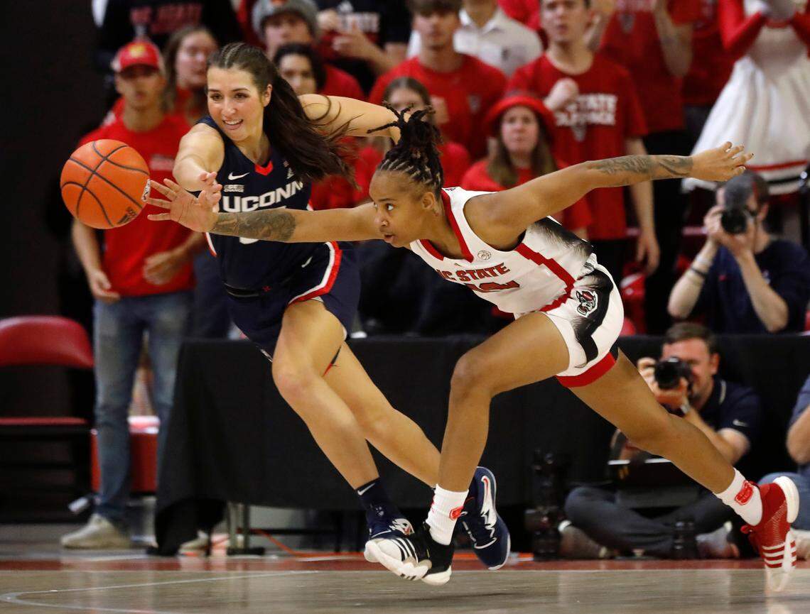 N.C. State’s Aziaha James and UConn’s Caroline Ducharme dive after a loose ball during the second half of the Wolfpack’s 92-81 win on Sunday, Nov. 12, 2023, at Reynolds Coliseum in Raleigh, N.C.
