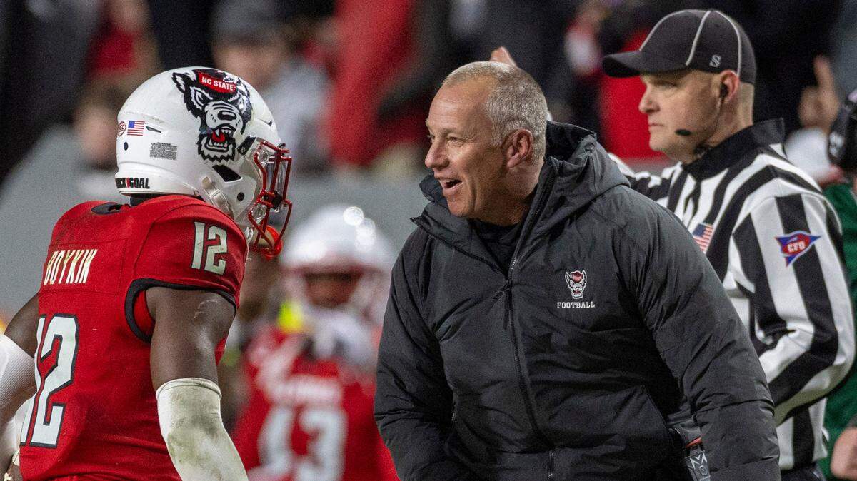 N.C. State coach Dave Doeren celebrates with Devan Boykin (12) after he intercepted a Drake Maye pass to secure the Wolfpack’s 39-20 over North Carolina victory on Saturday, November 25, 2023 at Carter-Finley Stadium in Raleigh, N.C.