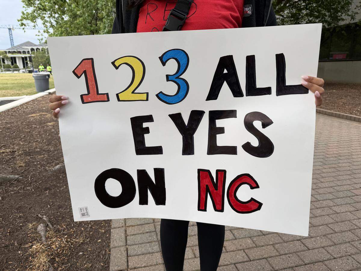 A protester displays their sign supporting teachers before the march in downtown Raleigh.