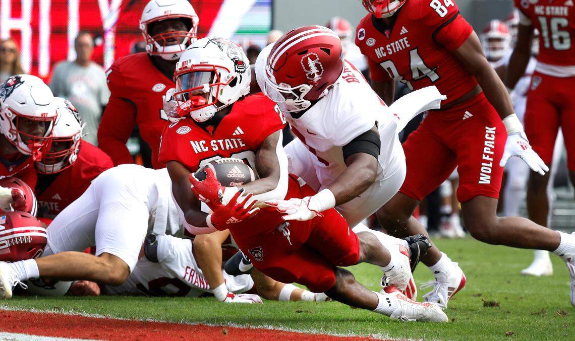 N.C. State running back Hollywood Smothers (20) dives in a two-yard touchdown run as Stanford linebacker Gaethan Bernadel (0) defends during the first half of N.C. State’s game against Stanford at Carter-Finley Stadium in Raleigh, N.C., Saturday, Nov. 2, 2024.
