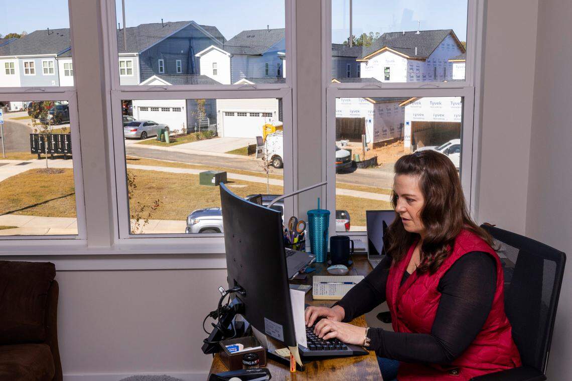 Amanda Suchanek, 38, works at her home office in her new townhouse in the Townes at Chatham Park subdivision in Pittsboro as construction continues outside her second-story window.