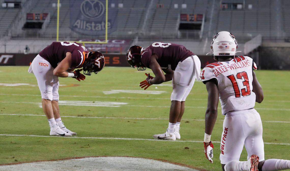 Virginia Tech’s James Mitchell (82), center, celebrates with Nick Gallo (86) after scoring on a 15-yard touchdown reception during the first half of N.C. State’s game against Virginia Tech at Lane Stadium in Blacksburg, VA Saturday, Sept. 26, 2020. N.C. State defensive back Tyler Baker-Williams (13) is to the right.
