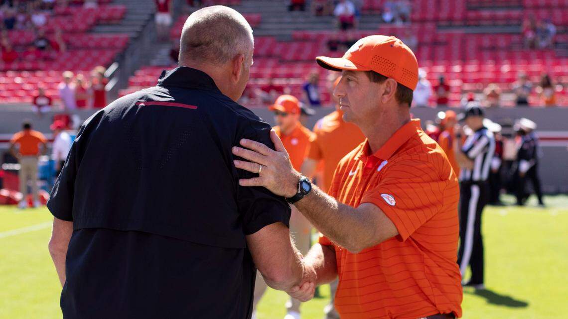 Clemson coach Dabo Swinney talks with N.C. State coach Dave Doeren prior to their game on Saturday September 25, 2021 at Carter-Finley Stadium in Raleigh, N.C.