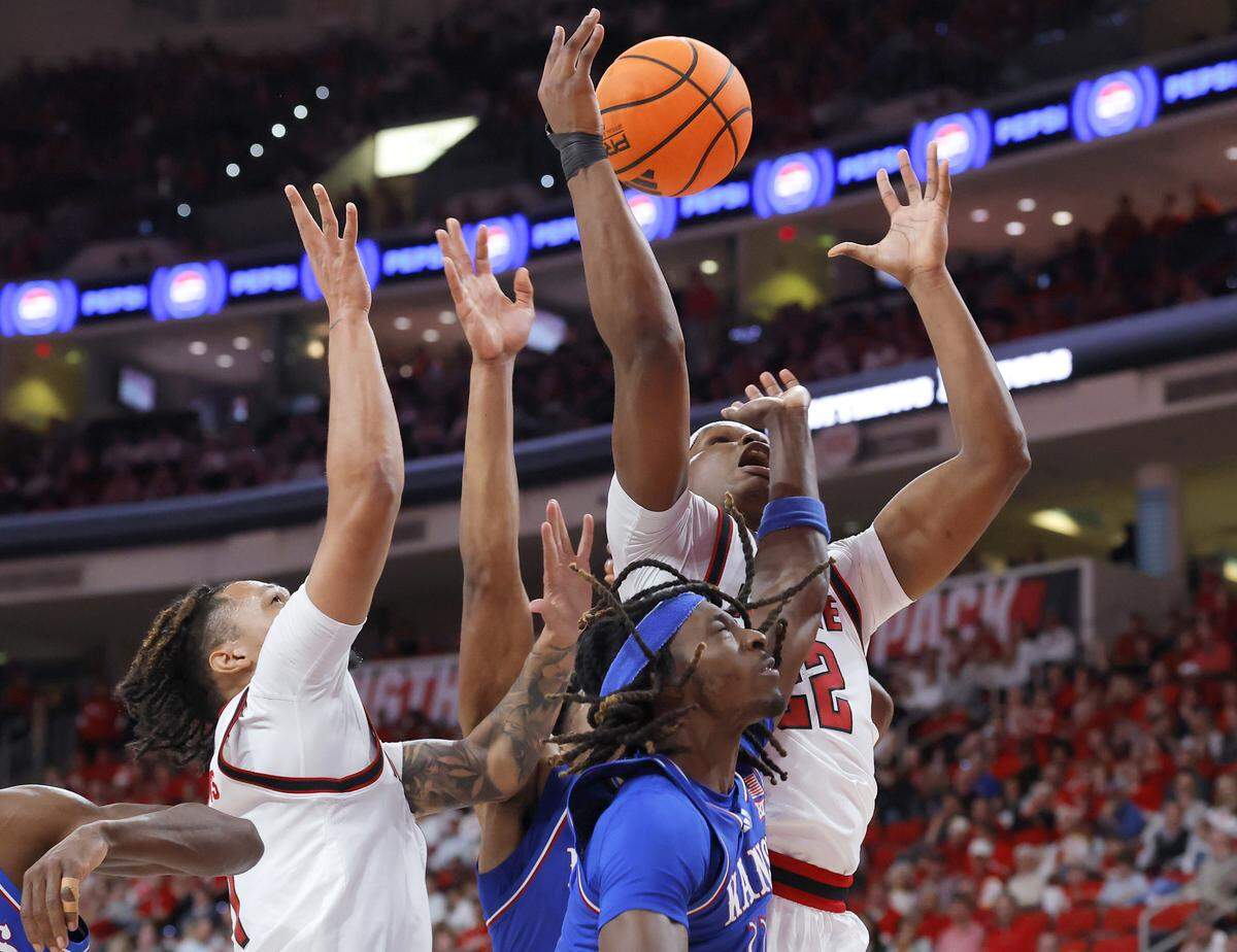 N.C. State’s Darrion Williams and Ven-Allen Lubin battle for a rebound with Kansas’ Jamari McDowell during the first half of the Wolfpack’s game on Saturday, Dec. 13, 2025, at Lenovo Center in Raleigh, North Carolina.
