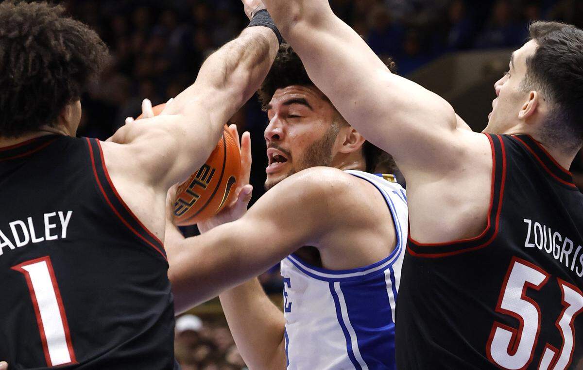 Duke’s Cameron Boozer (12) is double teamed by Louisville's J'vonne Hadley (1), left, and Vangelis Zougris (53) during the first half of Duke’s game against Louisville at Cameron Indoor Stadium in Durham, N.C., Monday, Jan. 26, 2026.