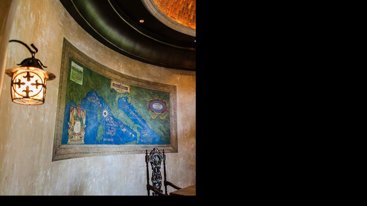  Above: A plaster piece de resistance located on the curvilinear wall in the dining room of a Tuscan-style villa features Jennifer Bertrand's hand-painted map of Italy modeled after painted images in the Gallery of Maps room in the Vatican Museum. While the sandstone-colored plaster was still wet, Bertrand added green and blue pigments to color-block the land and sea.

