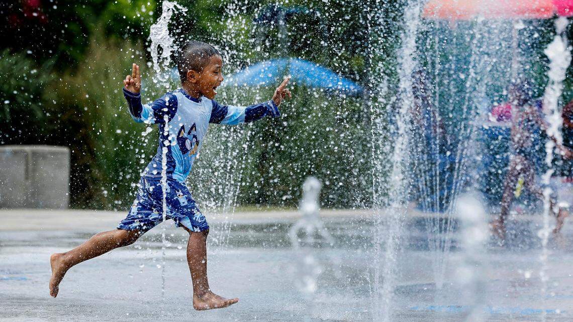 Five-year-old Isaac Arellanes of Raleigh enjoys the splash pad at John Chavis Memorial Park while cooling down with his brothers and sister in Raleigh, N.C., Thursday, June 20, 2024.