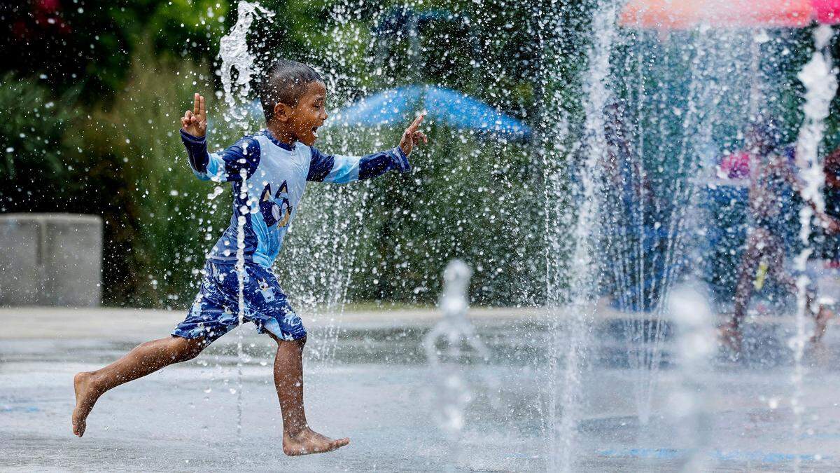 Five-year-old Isaac Arellanes of Raleigh enjoys the splash pad at John Chavis Memorial Park while cooling down with his brothers and sister in Raleigh, N.C., Thursday, June 20, 2024.