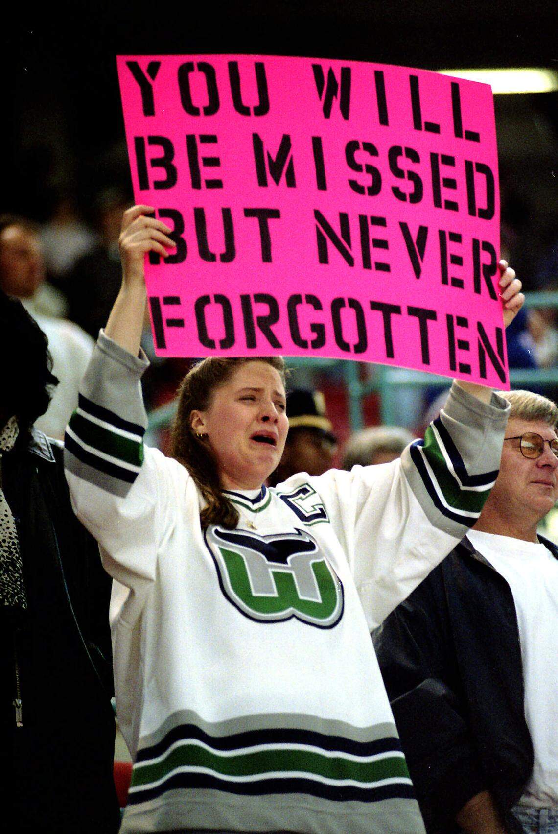Hartford Whalers fan Jennifer Rice cries as she holds up a sign at the end of the Hartford Whalers-Tampa Bay Lightning NHL game in Hartford, Conn., Sunday, April 13, 1997. The Whalers played their last game in Hartford Sunday before departing. The team’s destination is unknown. (AP Photo/Steve Miller)