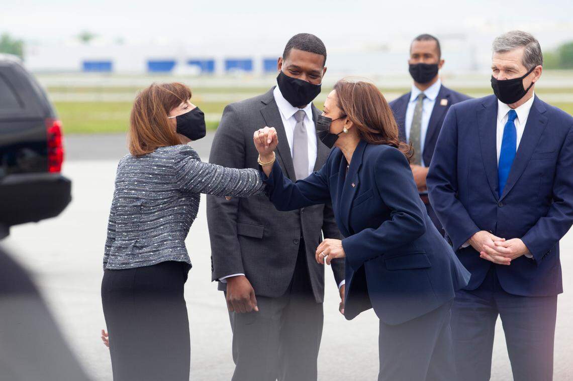 Vice President Kamala Harris elbow bumps U.S. Rep Kathy Manning, left, while being greeted by Environmental Protection Agency Administrator Michael Regan and Gov. Roy Cooper, right, as Harris steps off Air Force Two on Monday April 19, 2021 at Piedmont Triad International Airport in Greensboro.