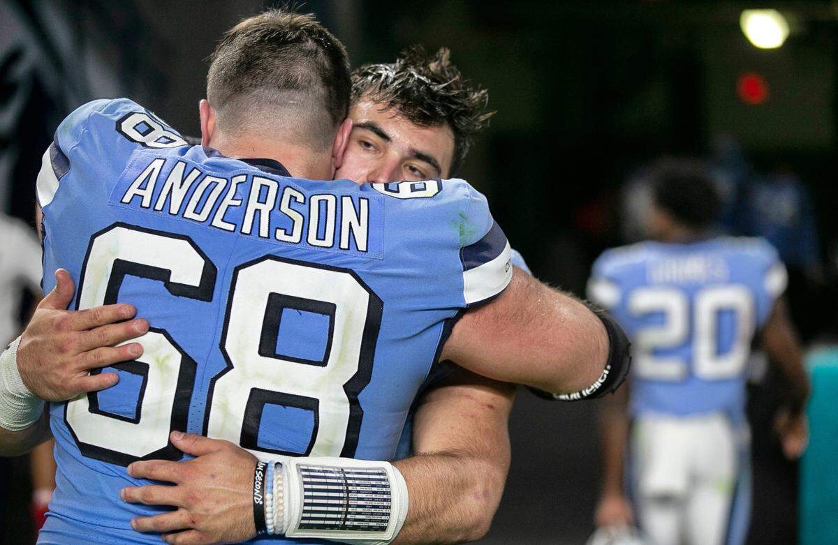 North Carolina’s Brian Anderson (68) embraces quarterback Sam Howell following the Tar Heels’ 41-27 loss to Texas A&M in the Capital One Orange Bowl on Saturday, January 2, 2021in Miami Gardens, Florida. 