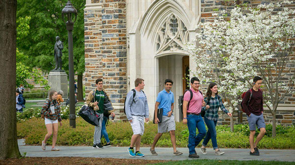 Duke University tudents walk to and from class past Rubenstein Library through the Academic Quad.