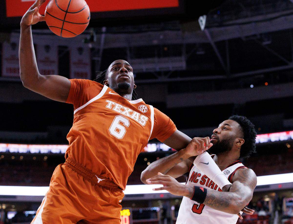 Texas’ Arthur Kaluma and N.C. State’s Dontrez Styles battle for a rebound during the first half of the Wolfpack’s game on Wednesday, Dec. 4, 2024, at Lenovo Center in Raleigh, N.C.