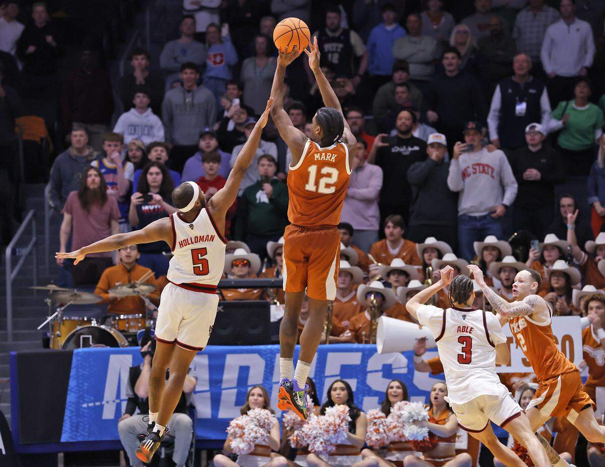 Texas’ Tramon Mark shoots over N.C. State’s Tre Holloman with seconds remaining in the Wolfpack’s 68-66 loss in the NCAA First Four on Tuesday, March 17, 2026, at the University of Dayton Arena in Dayton, Ohio. 