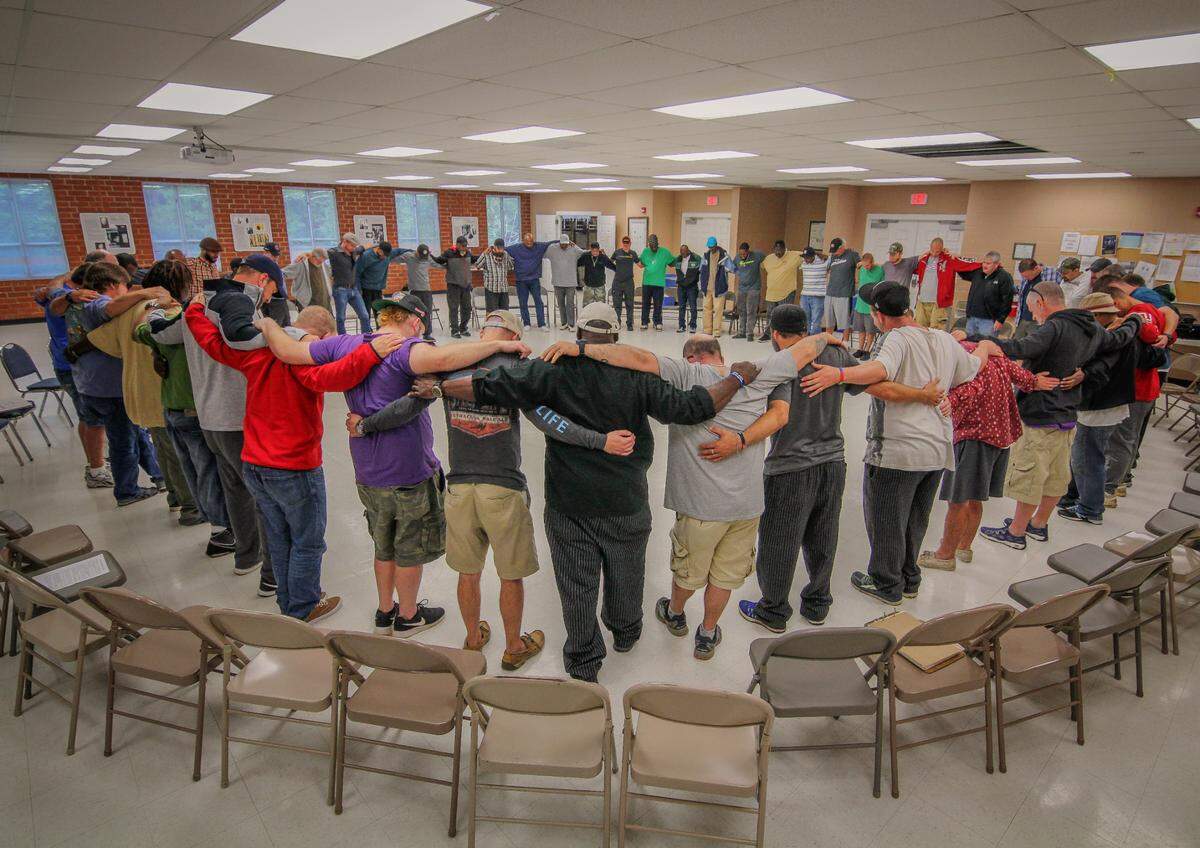 Men gather for a community session at the men’s campus of Healing Transitions.