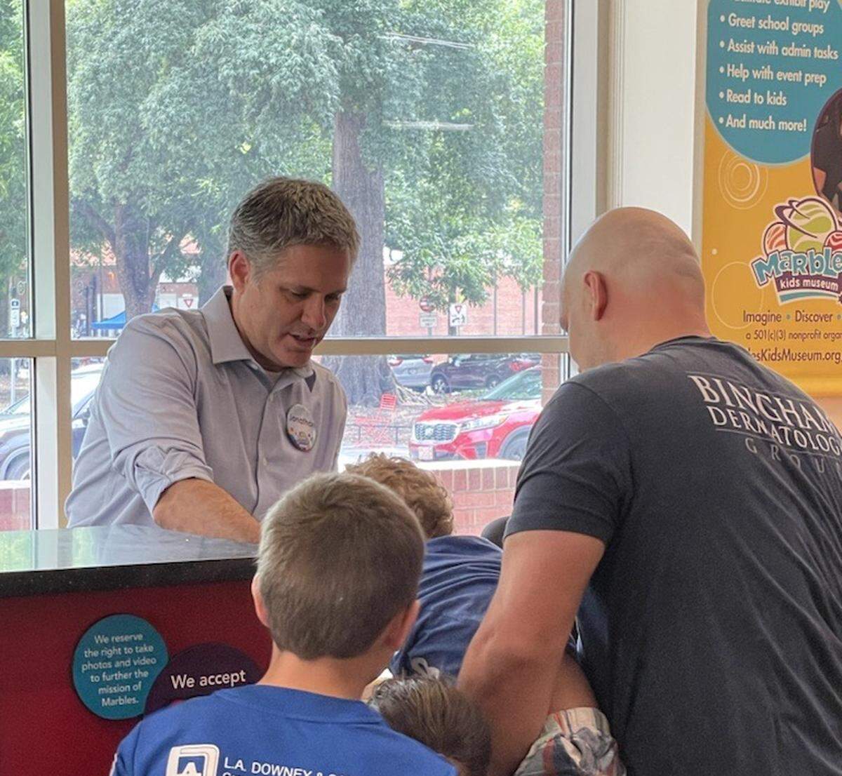 Jonathan Frederick, who stepped into his new role as CEO of Marbles Kids Museum in June 2022, checks a visitors in at the museum’s welcome desk. Frederick is helping set the vision and strategy for the museum’s future at a time when visitor levels are climbing again.