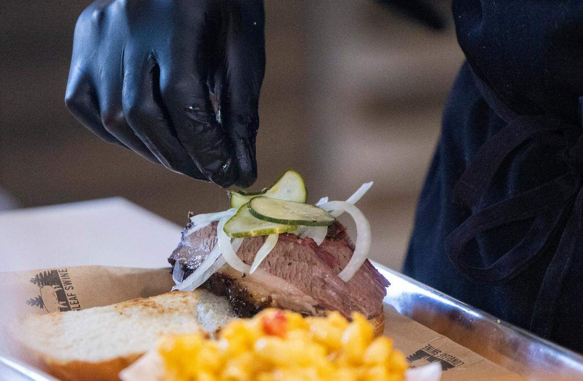 A brisket sandwich is prepared during the opening of Longleaf Swine in Raleigh Friday, Nov. 4, 2022.
