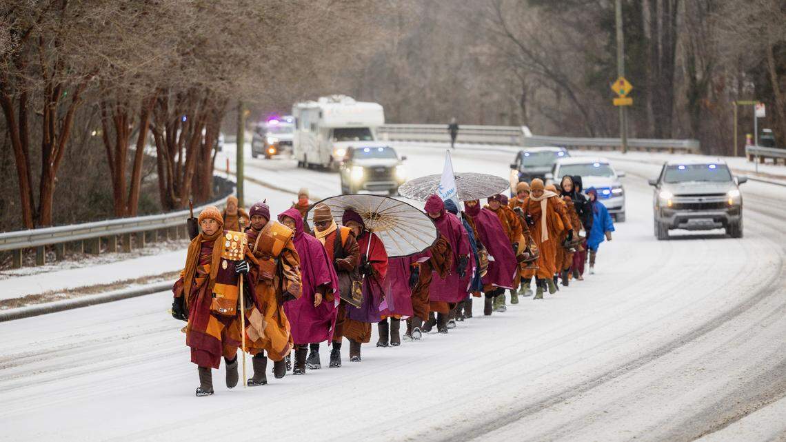 A procession of Buddhist monks walks along snow-covered Raleigh Boulevard in Raleigh on Sunday morning, Jan. 25, 2026. The monks are making a 2,300-mile pilgrimage from Texas to Washington, D.C., as part of the Walk for Peace, an effort to promote peace, compassion and loving kindness.