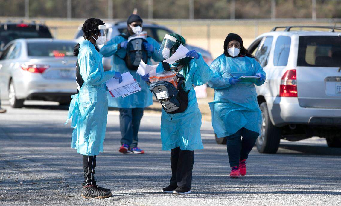 Dressed in their personal protective equipment, staff from One Love Services collect samples during a food distribution and COVID-19 testing event at the Greene County Senior Center on Thursday, December 3, 2020 in Snow Hill, N.C.