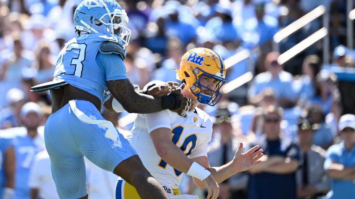 Oct 5, 2024; Chapel Hill, North Carolina, USA; Pittsburgh Panthers quarterback Eli Holstein (10) passes the ball as North Carolina Tar Heels linebacker Power Echols (23) pressures in the second quarter at Kenan Memorial Stadium. Mandatory Credit: Bob Donnan-Imagn Images