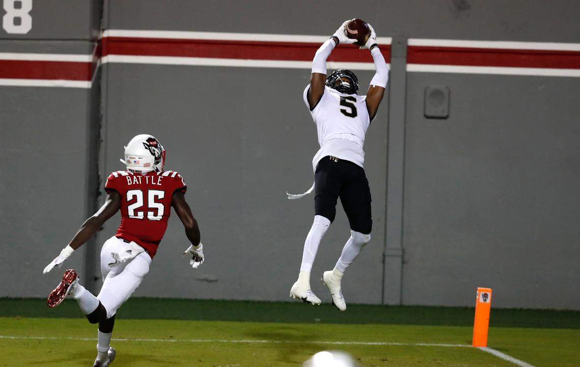 Wake Forest wide receiver Jaquarii Roberson (5) makes a 5-yard touchdown reception as N.C. State cornerback Shyheim Battle (25) defends during the first half of N.C. State’s game against Wake Forest at Carter-Finley Stadium in Raleigh, N.C, Saturday, Sept. 19, 2020.