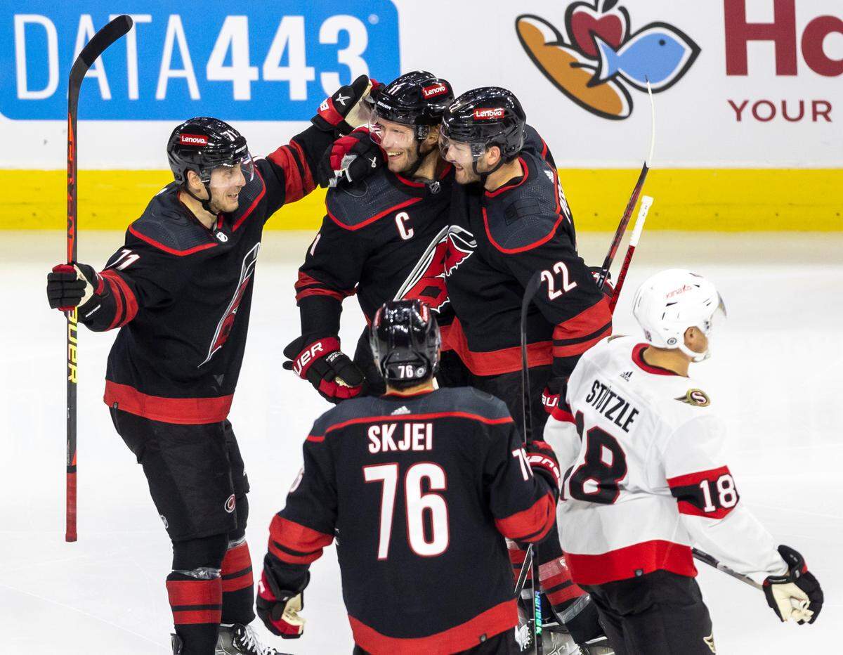 The Carolina Hurricanes Jesper Fast (71) and Brett Pesce (22) celebrate with Jordan Staal (11) after his goal in the third period on Wednesday, October 11, 2023 at PNC Arena, in Raleigh N.C.