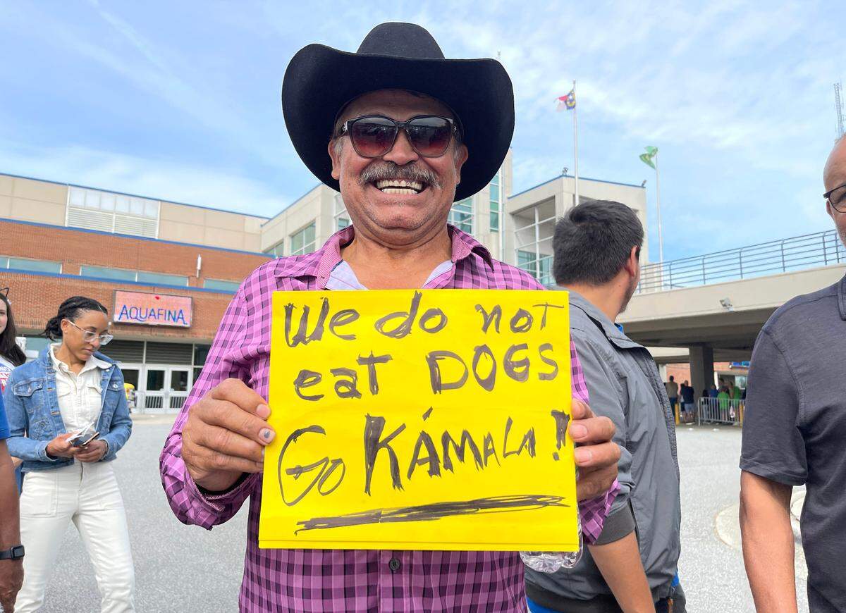 Juan Frias of Lillington holds up his sign while waiting in line to attend a rally for Vice President and democratic nominee for president Kamala Harris at the Greensboro Coliseum in Greensboro, N.C., Thursday, Sept. 12, 2024.
