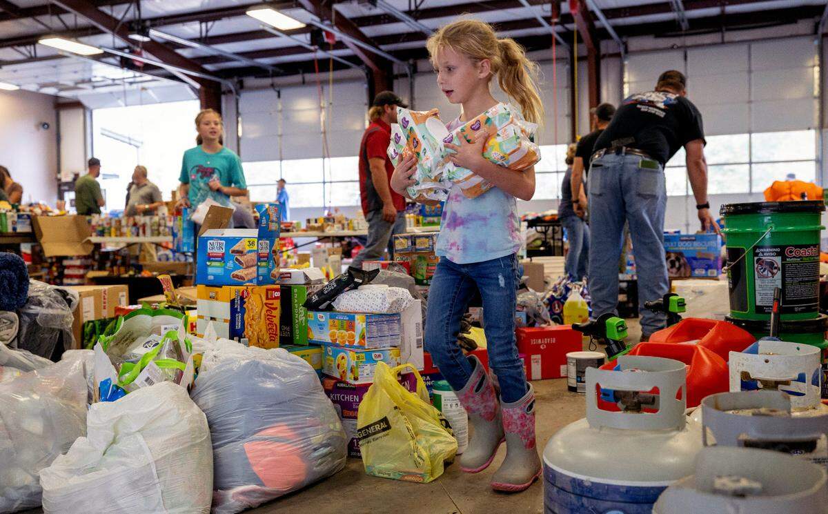 Seven-year-old Amersyn Rutledge of Greenville TN, sorts donated supplies at the Pensacola Fire Department on Thursday, October 3, 2024 in Pensacola, N.C. Amersyn came with her father to volunteer on Thursday as the hard hit community, cut off by damaged roads from Hurricane Helene copes with limited resources and medical supplies.