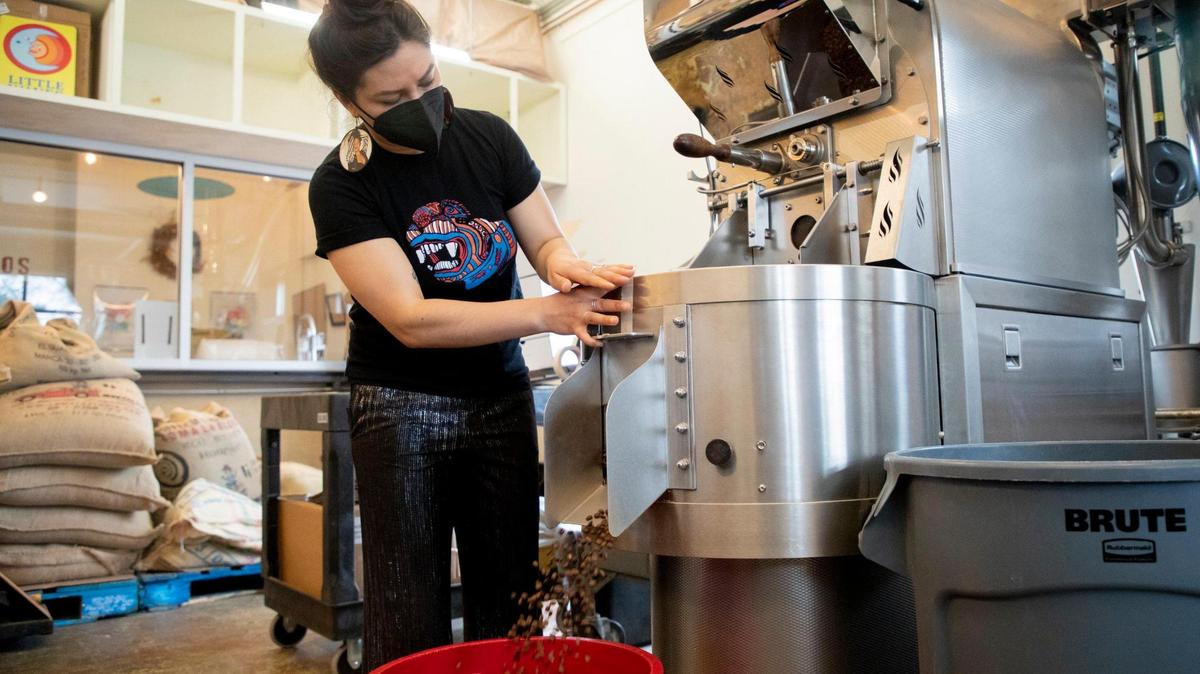 Areli Barrera de Grodski, co-owner of Cocoa Cinnamon and Little Waves Coffee Roasters, empties freshly roasted coffee beans into a container, on Wednesday, Mar. 31, 2021, in Durham, N.C. The company was recently named Roaster of the year by an industry magazine.
