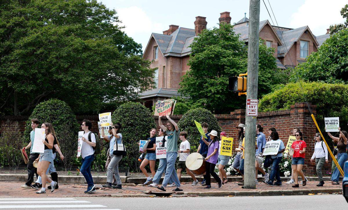 Protesters walk around the N.C. Executive Mansion during a rally and march organized by NC WARN in Raleigh, N.C., Saturday, April 26, 2025. About 85 people gathered to pressure Gov. Josh Stein to speak out against Duke Energy and push the state’s monopoly utility to embrace renewable energy.