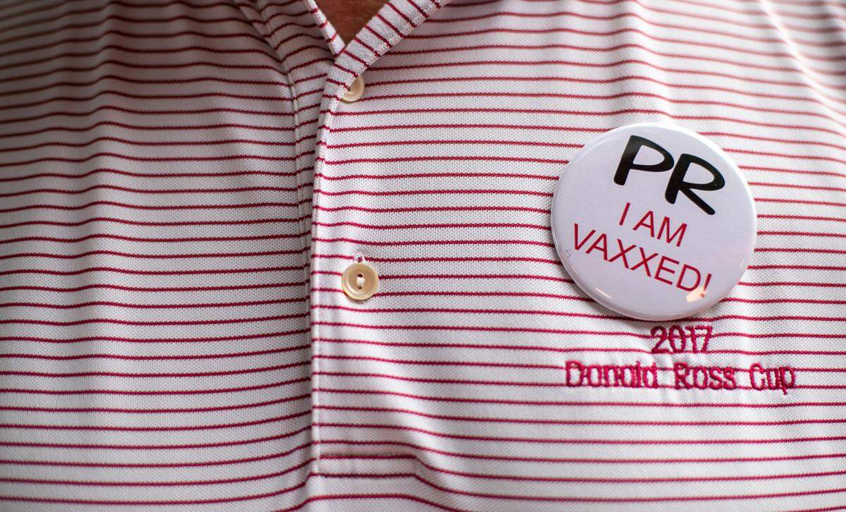 Players Retreat owner Gus Gusler wears one of the buttons that he will require customers to register for and wear to enter his business when it re-opens on June 23, 2021. Customers can register for their buttons beginning next week.
