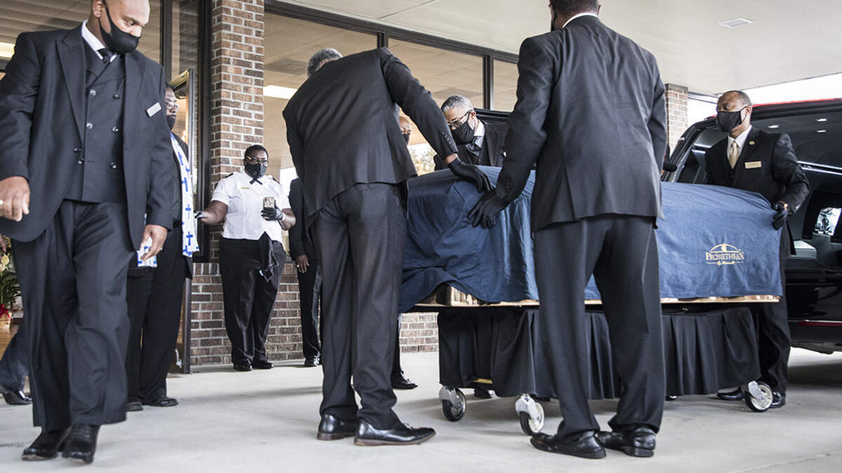 George Floyd’s casket is removed from a hearse outside the entrance to the R.L. Douglas Cape Fear Conference Center for a public viewing and private memorial service on Saturday, June 6, 2020 in Raeford, N.C. where Floyd was born.