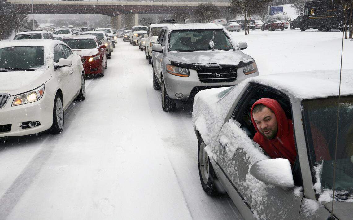 Kevin Miller looks out of the passenger window of his friend's car as they sit stuck in afternoon traffic on Feb. 12, 2014, after snow and ice caused massive traffic jams in Raleigh.